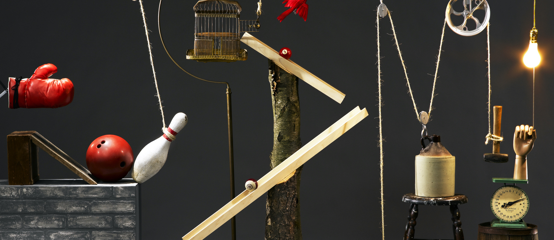 An image of a rube goldberg machine with a gray background